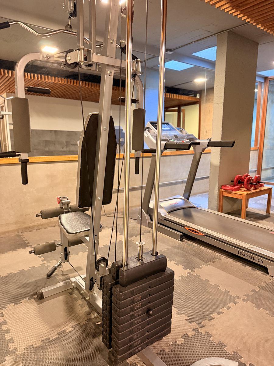Máquina de musculación y cinta en el gimnasio del edificio Aliwen