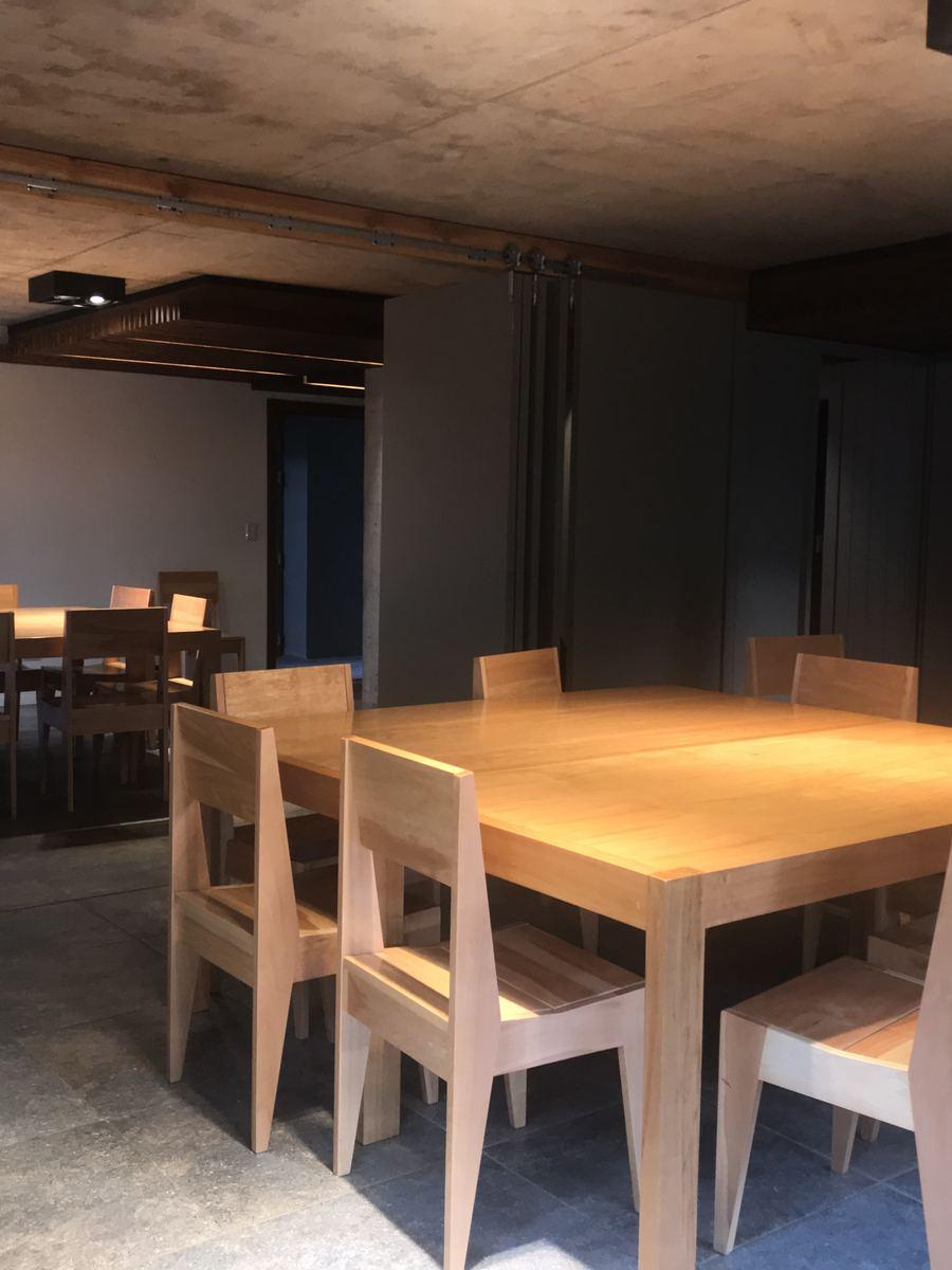 Salón del quincho con mesas de madera en el edificio Aliwen