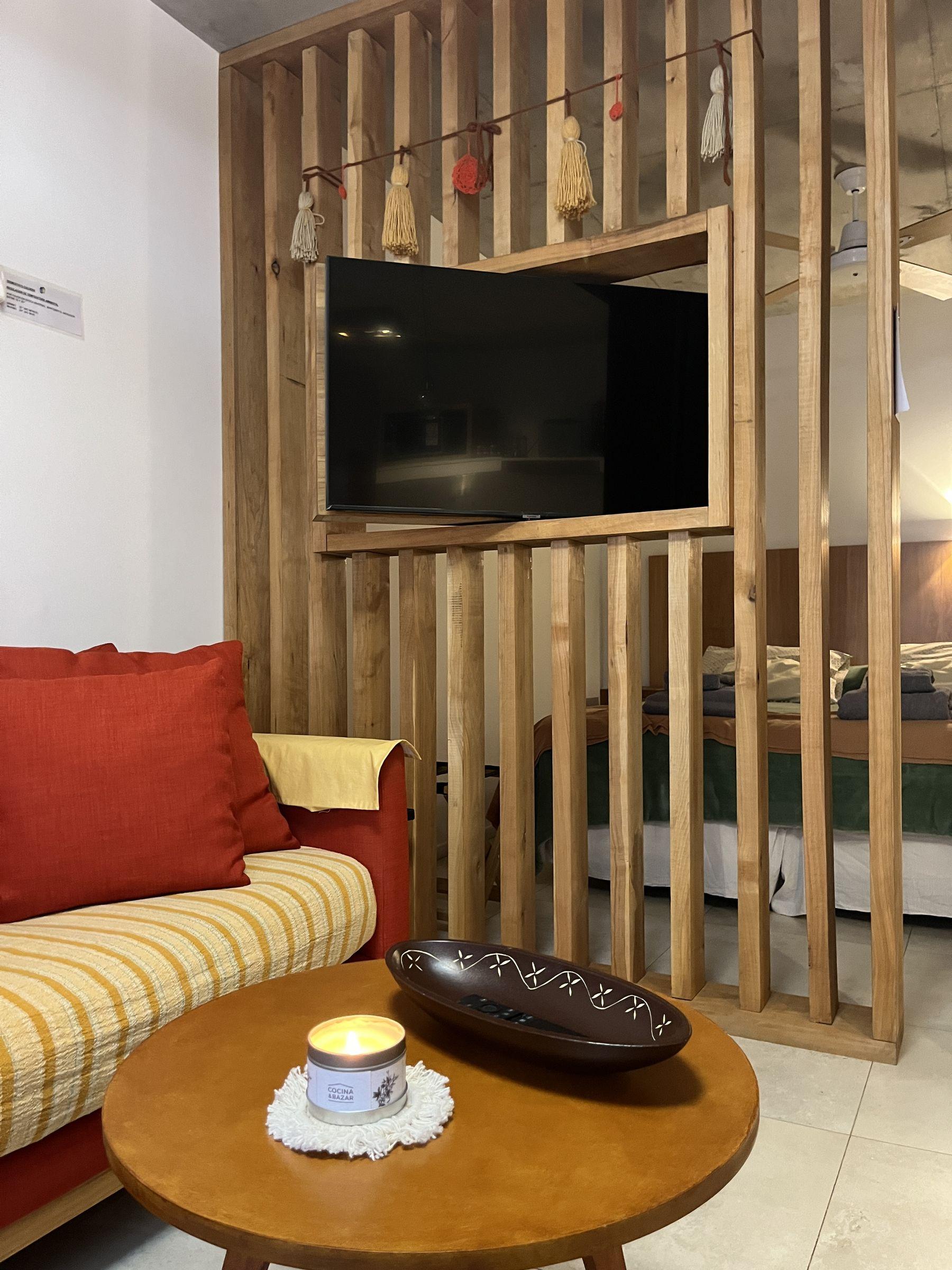 Living con sillón y divisor de madera del departamento Lenga en Aliwen